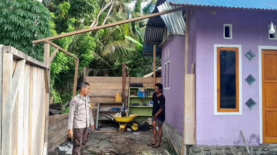 Bhabinkamtibmas Polsek Nuhon Datangi TKP Rumah Tertimpa Pohon Tumbang di Desa Balaang