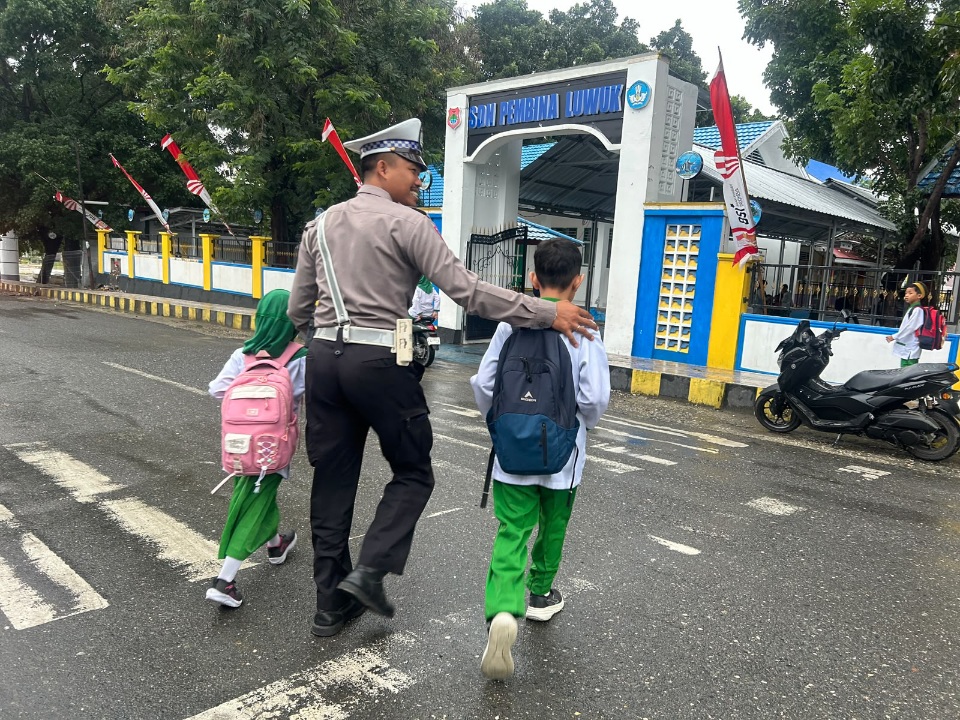 Beri Rasa Aman, Satlantas Polresta Banggai Bantu Anak Sekolah Nyebrang Jalan